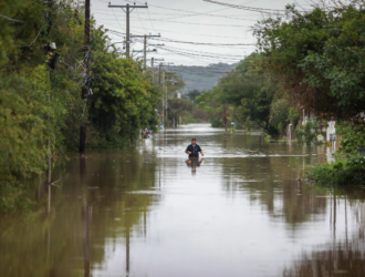 homem caminhando em rua inundada