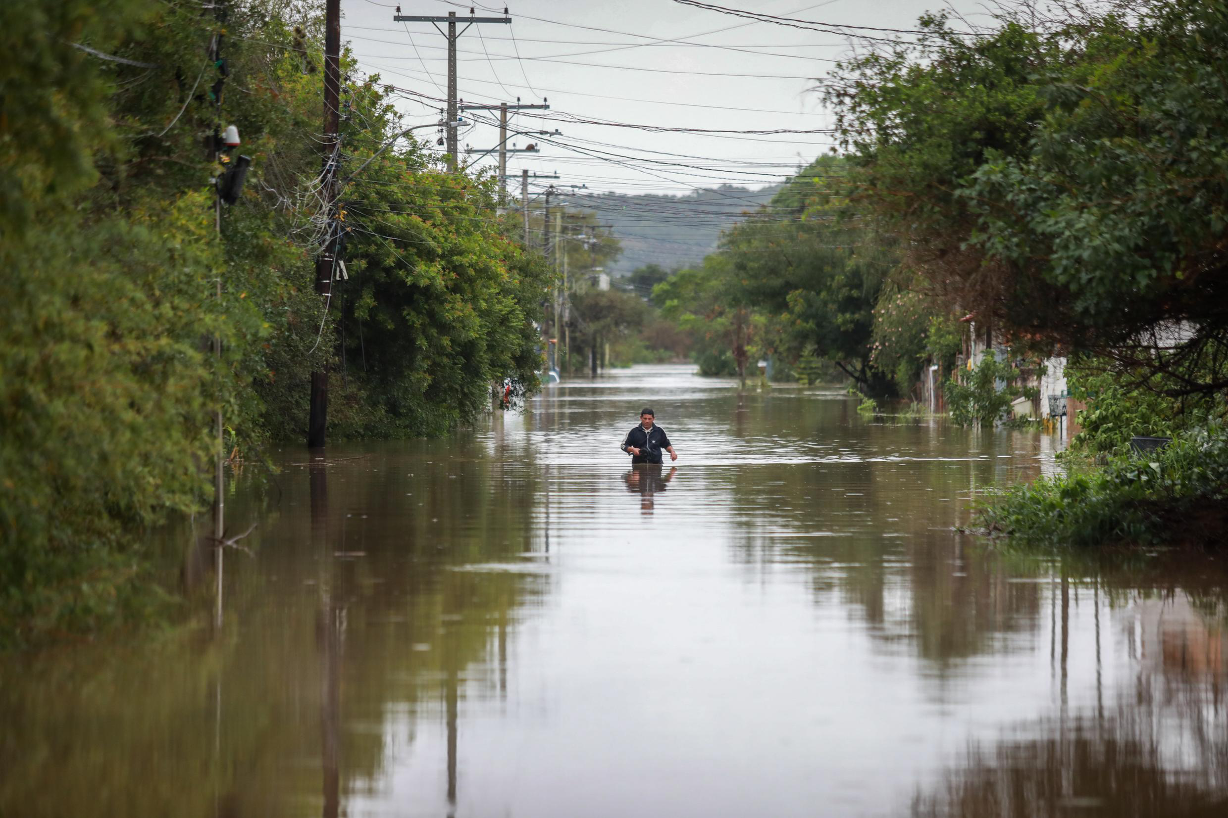 homem caminhando em rua inundada